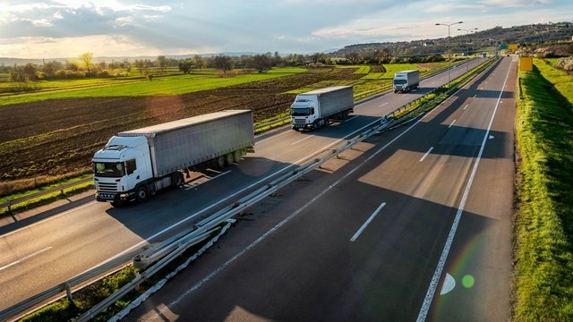 Três camiões numa autoestrada